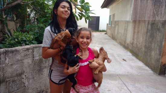 Thaís e Roberta, filhas de Rosimeri, ajudam a mãe nos cuidados com os cachorros.