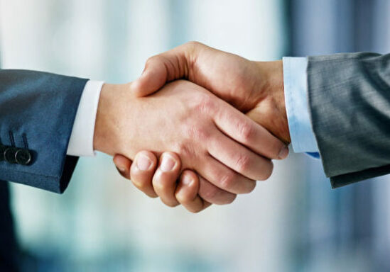 Closeup shot of two businessmen shaking hands in an office