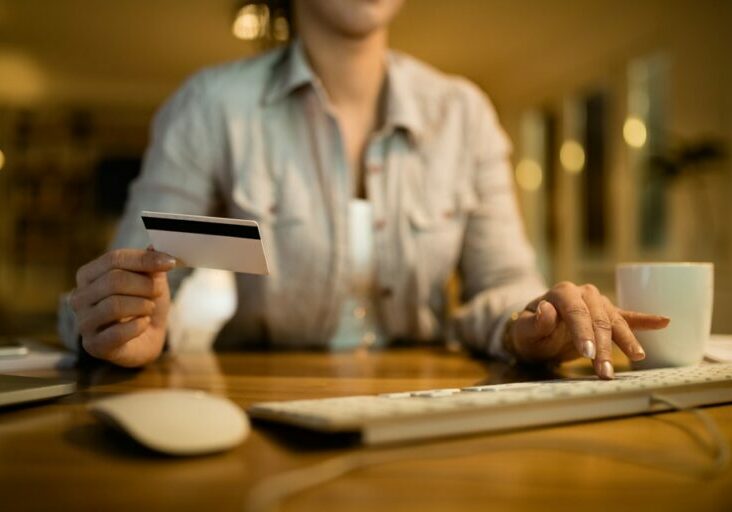 closeup-woman-using-computer-credit-card-online-banking-evening-home (1)