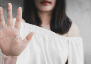 Closeup portrait young annoyed angry woman with bad attitude giving talk to hand gesture with palm outward isolated grey wall background. Negative human emotion face expression feeling body language.