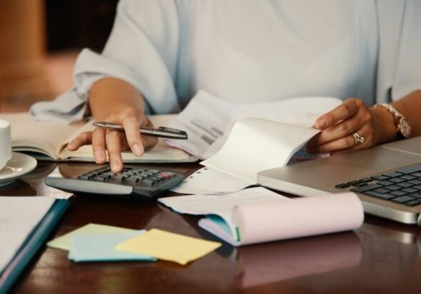 Hands of female entrepreneur working with bills and documents