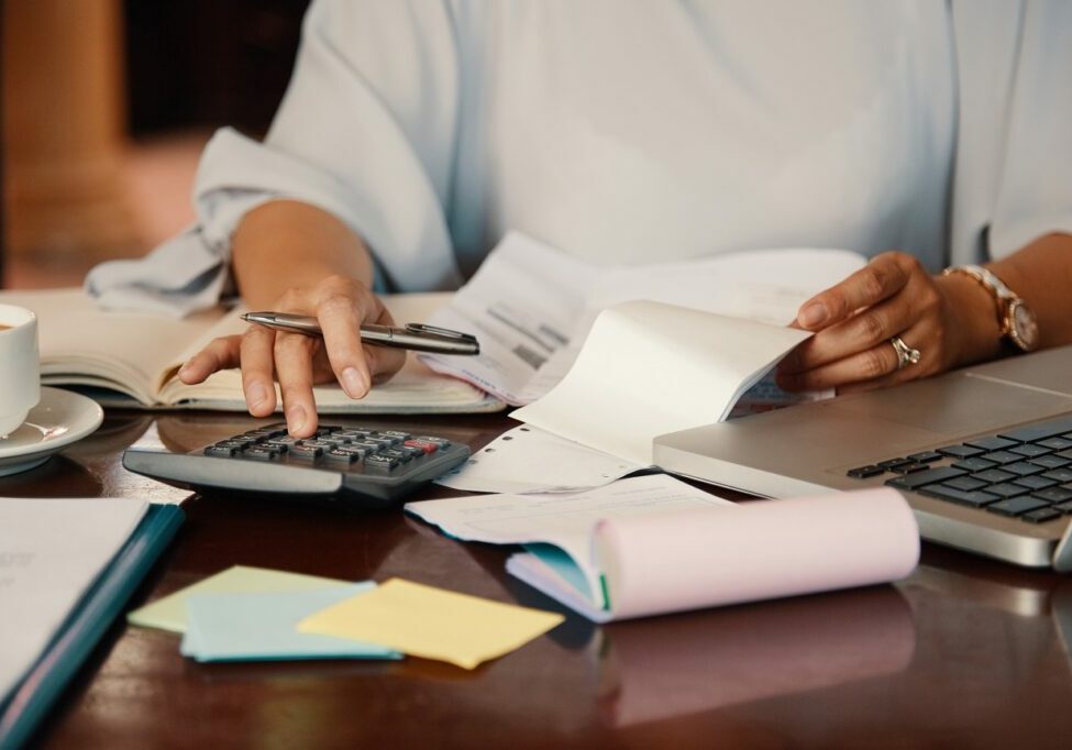 Hands of female entrepreneur working with bills and documents