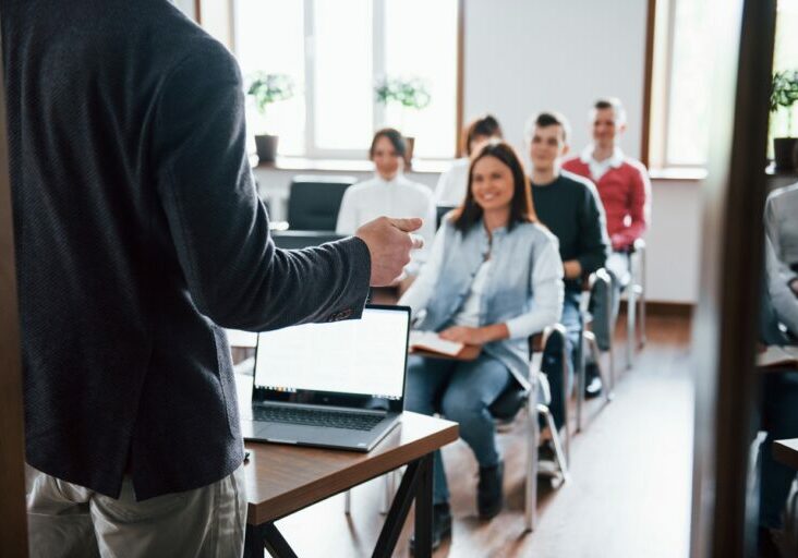 Cheerful mood. Group of people at business conference in modern classroom at daytime.