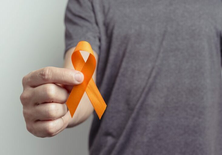 Man showing orange ribbon. Awareness ribbon.