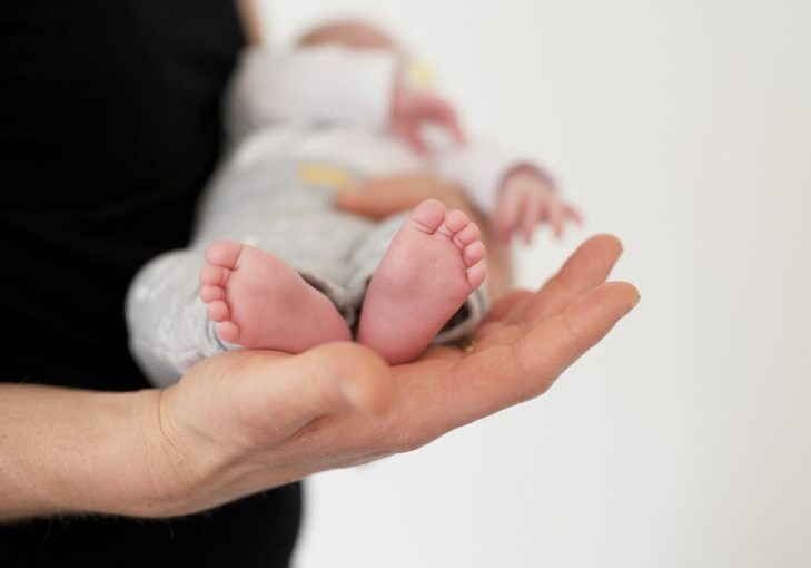 A selective focus shot of a person carrying a newborn baby