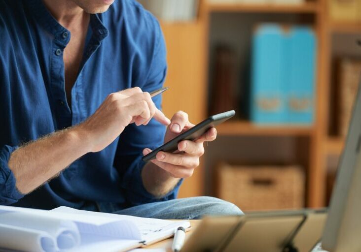 Hands of businessman with pen in his hand texting