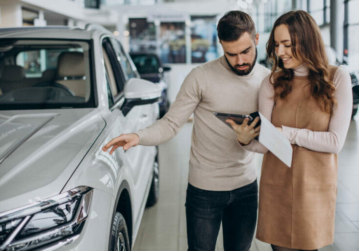 Saleswoman talking to customer in a car salon